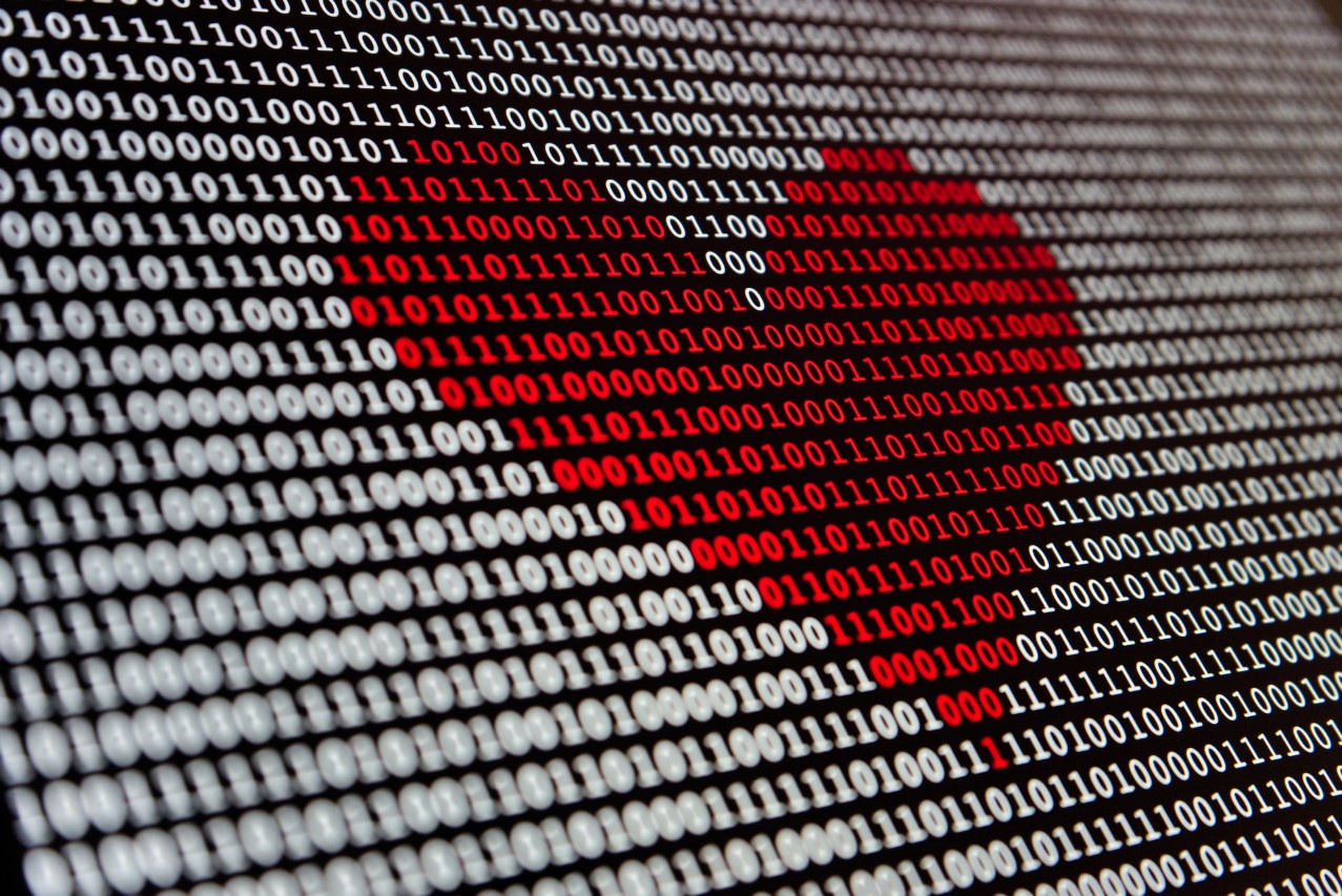 A heart is shown on a computer screen with 0s an 1s.
