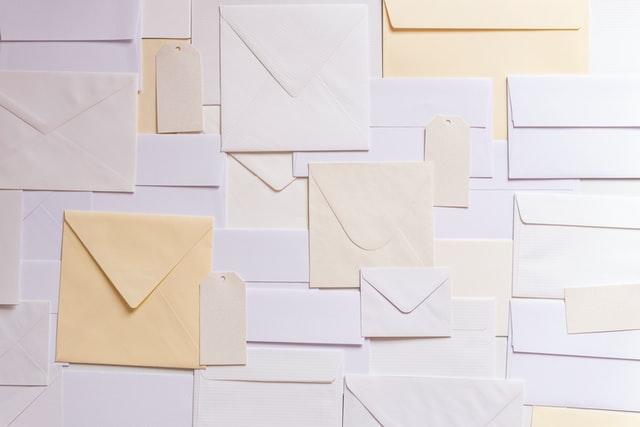 A wall with many different colored envelopes on it.